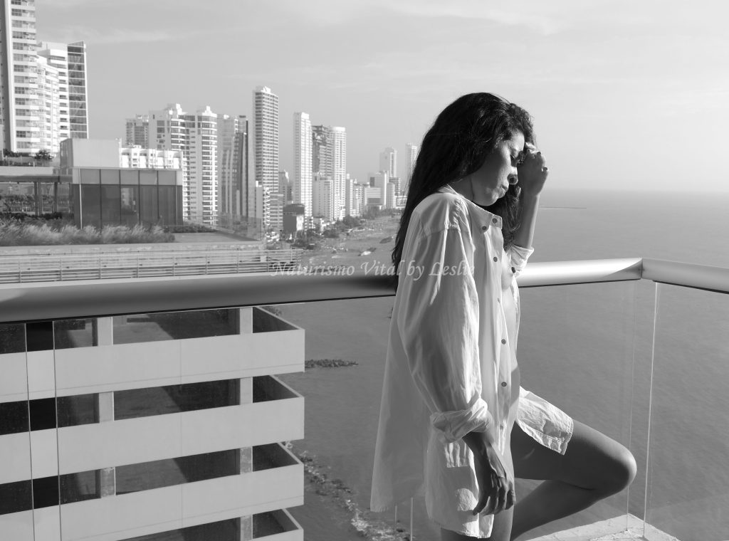 Silueta femenina natural con el atardecer de la ciudad, galería para Naturismo Vital